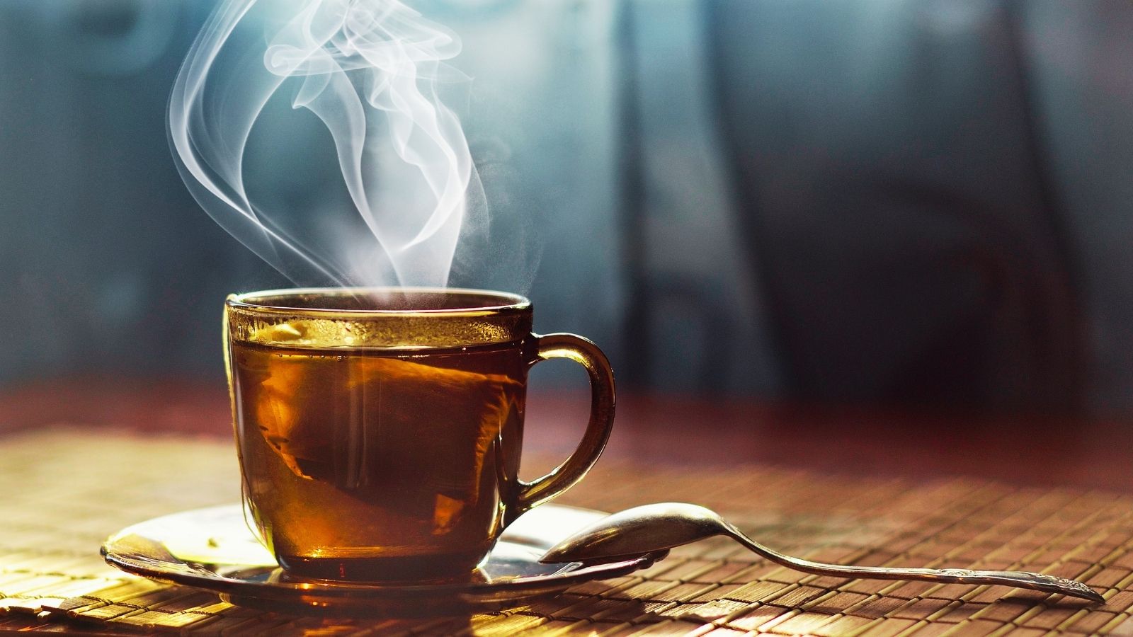 A steaming cup of tea resting on a table in soft light